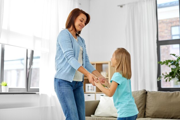 Foto mãe e filha a divertir-se em casa.