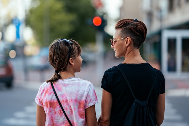 Mãe e filha à espera de luz verde para atravessar a rua