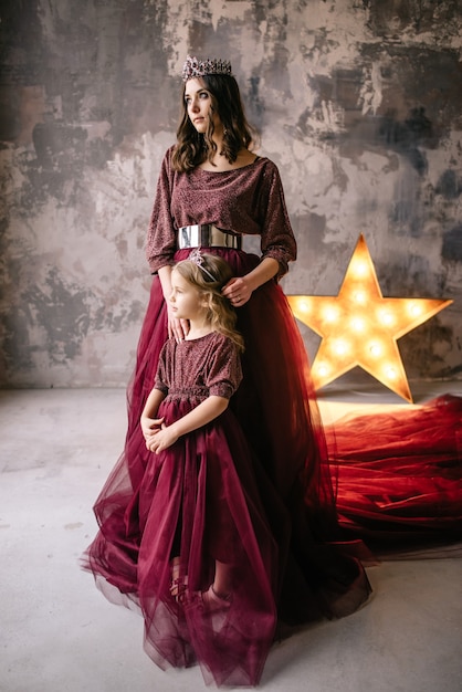 Mãe e filha à imagem da rainha e princesa vestidas nas cores de marsala com cauda comprida no loft