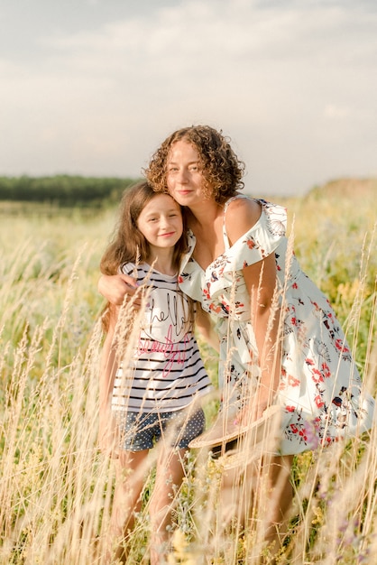 Mãe e filha abraçando no campo