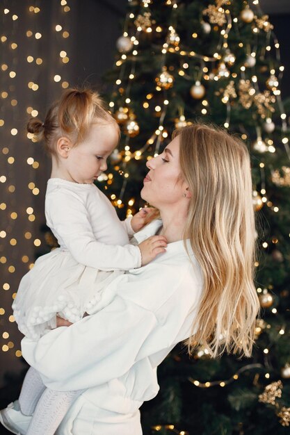 Mãe e filha abraçando perto da árvore de Natal