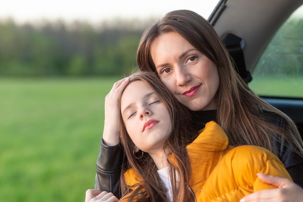 Mãe e filha acampando em uma colina