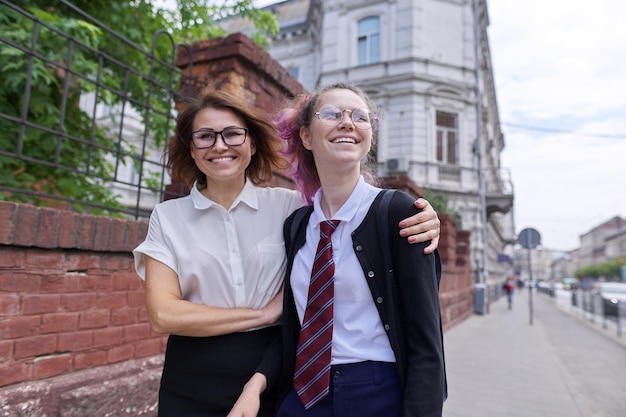 Mãe e filha adolescente caminhando juntos na rua da cidade. Falando mãe e aluna, pai e filho discutindo escola, estudo