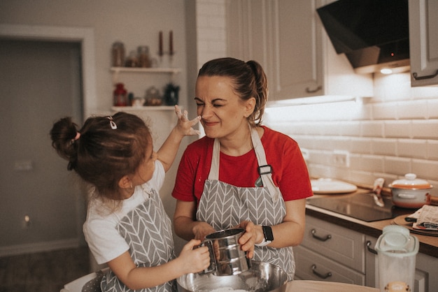 Foto mãe e filha amassam massa cozinhando