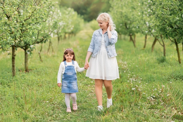 Mãe e filha andando no jardim primavera