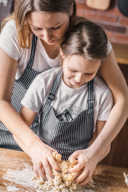 Mãe e filha aprendendo a fazer amassar