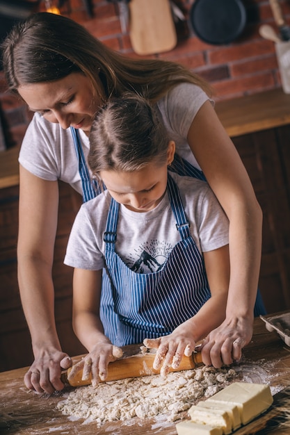 Mãe e filha aprendendo a rolar a massa