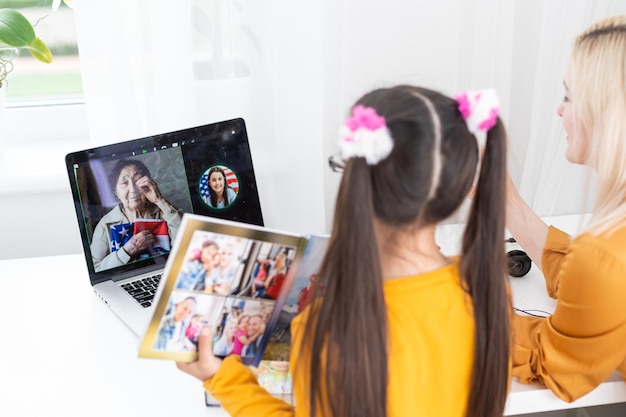 Mãe e filha assistem ao álbum de fotos da família.