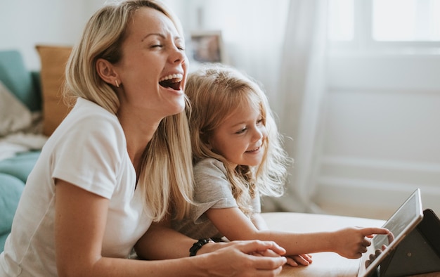 Mãe e filha assistindo a um desenho animado em um tablet digital