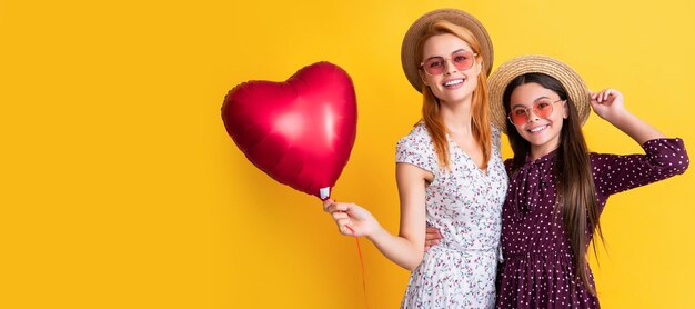 Mãe e filha banner copiam espaço fundo isolado feliz mãe e filha seguram balão de coração de amor em fundo amarelo