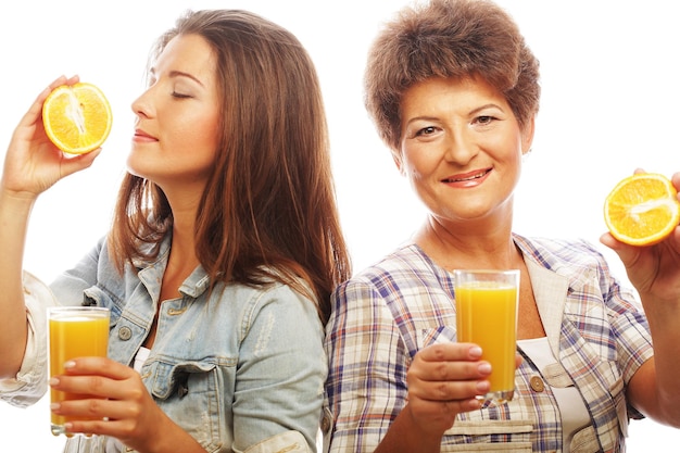 Mãe e filha bebendo suco de laranja