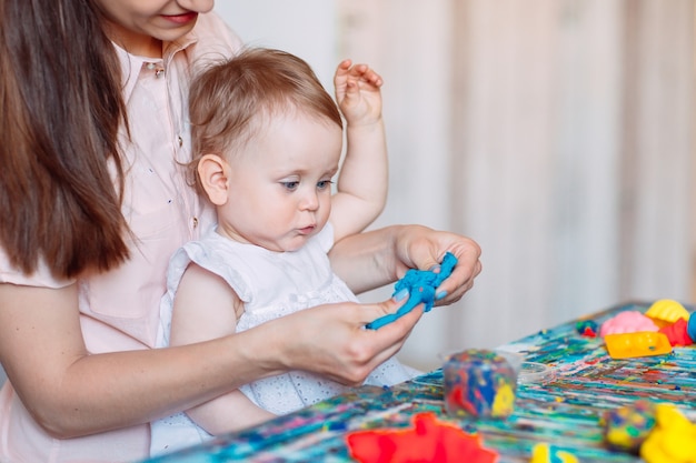 Mãe e filha brincando com a areia cinética.