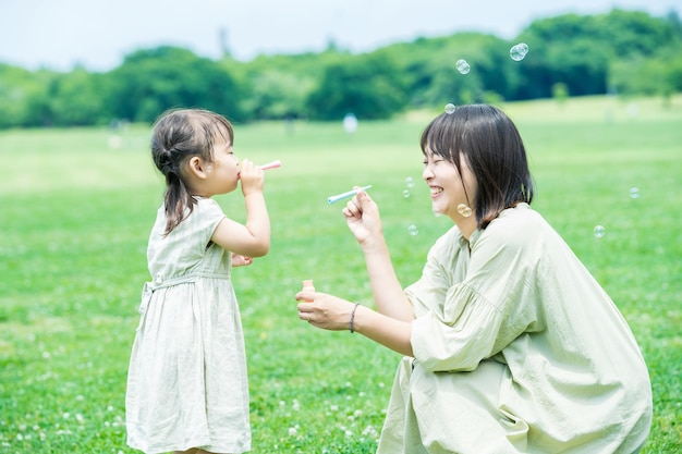 Mãe e filha brincando com bolhas de sabão