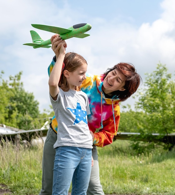 Mãe e filha brincando com o avião de brinquedo