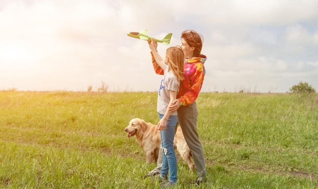 Mãe e filha brincando com o avião de brinquedo