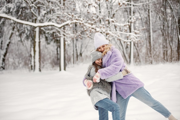 Mãe e filha brincando em bolas de neve no inverno