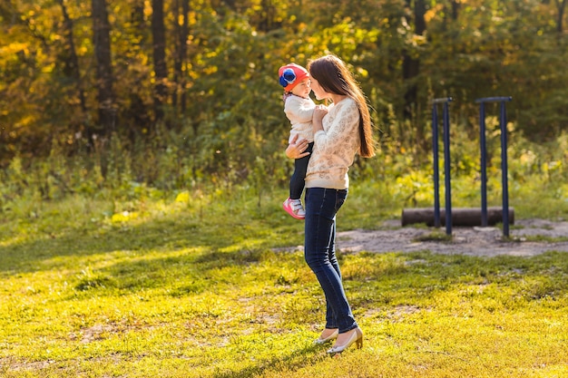 Mãe e filha brincando juntos no parque outono.