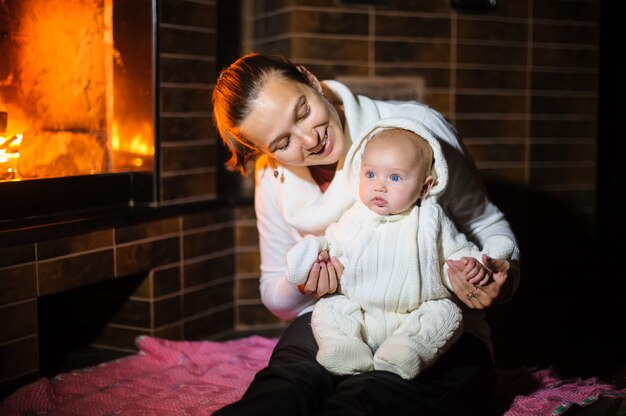 Mãe e filha brincando juntos perto da lareira