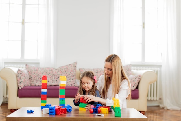 Mãe e filha brincando na sala