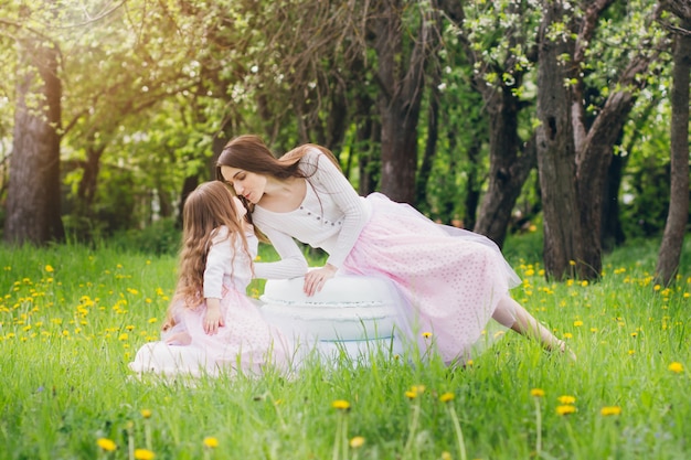 Mãe e filha caminham na primavera florescendo Apple