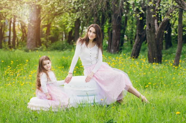 Mãe e filha caminham na primavera florescendo apple