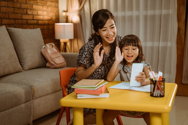 Mãe e filha chamando com smartphone