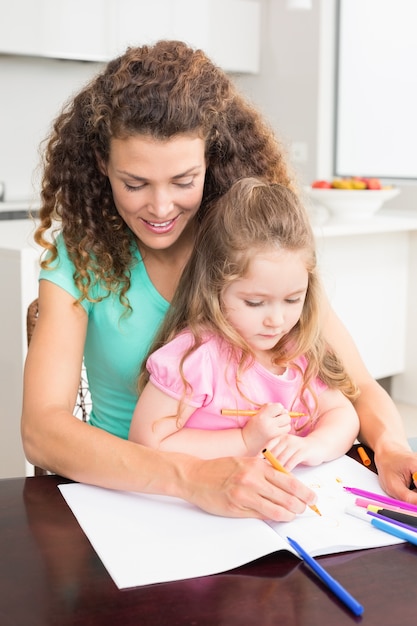 Mãe e filha coloridas junto à mesa