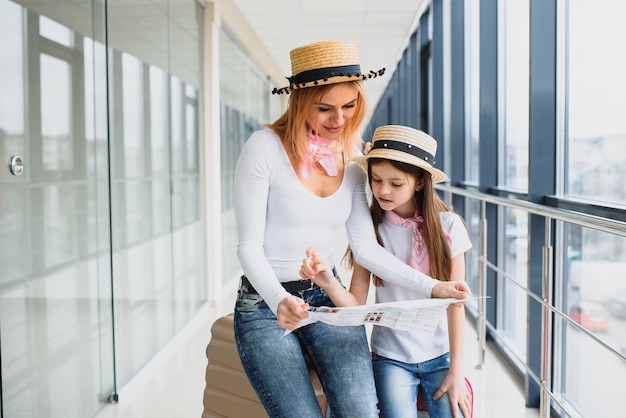 Mãe e filha com bagagem no aeroporto