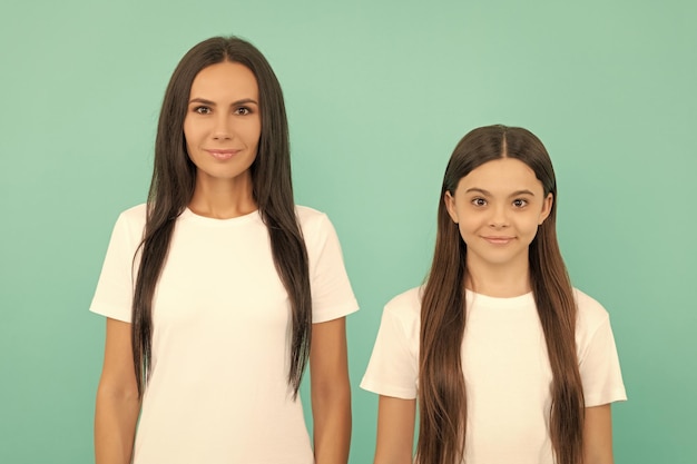 Mãe e filha com cabelo comprido em fundo azul