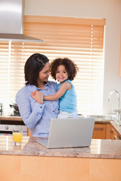 Mãe e filha com caderno na cozinha