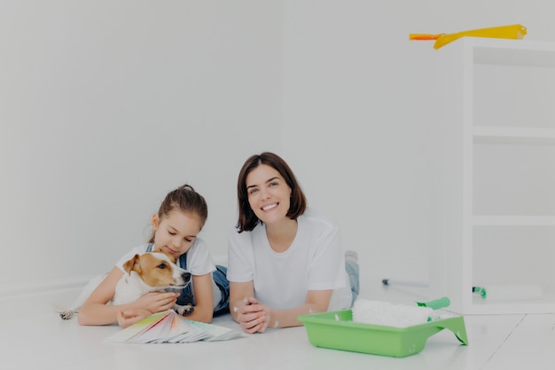 mãe e filha com seu cão de raça deitado no chão