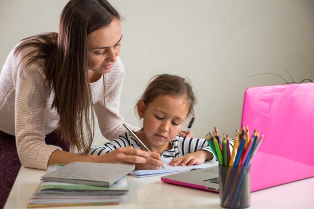 Mãe e filha com um livro na mesa