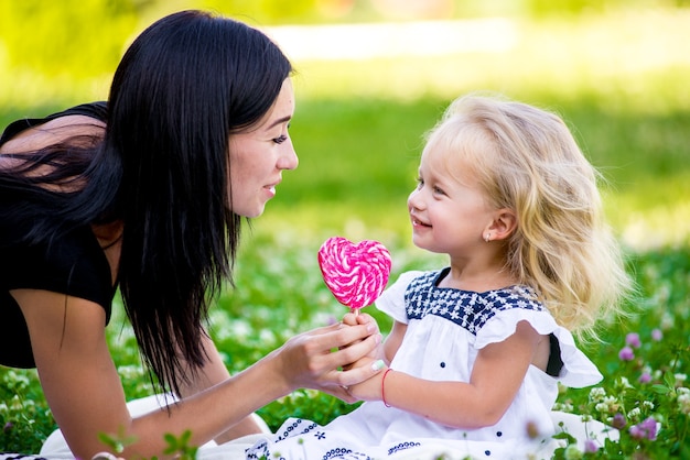 Mãe e filha comendo doces no espeto