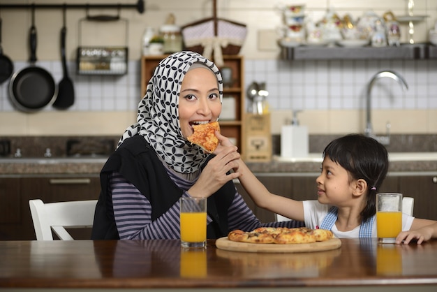 Mãe e filha comendo pizza