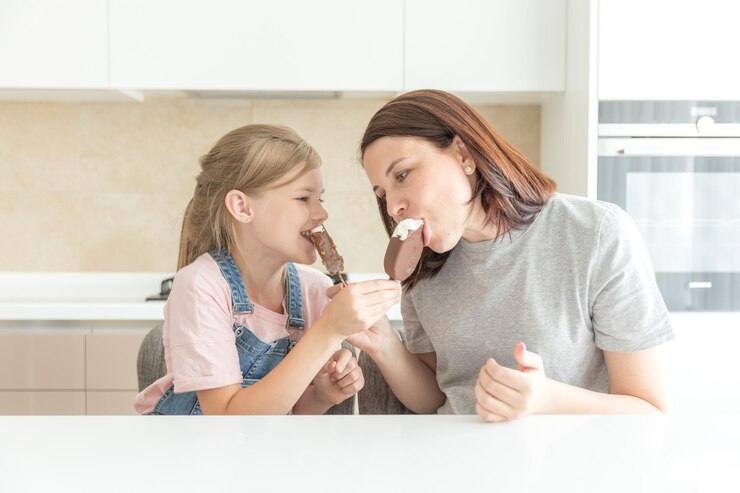 Foto mãe e filha comendo sorvete em casa