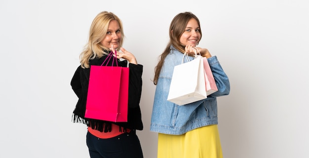 Mãe e filha comprando algumas roupas isoladas na parede branca