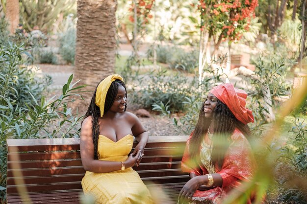 Foto mãe e filha conversando em seus trajes tradicionais africanos em uma cerimônia de festa religiosa