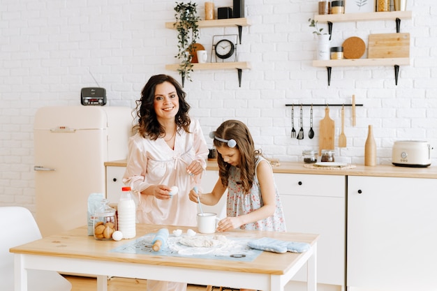 Mãe e filha cozinham juntas na cozinha.