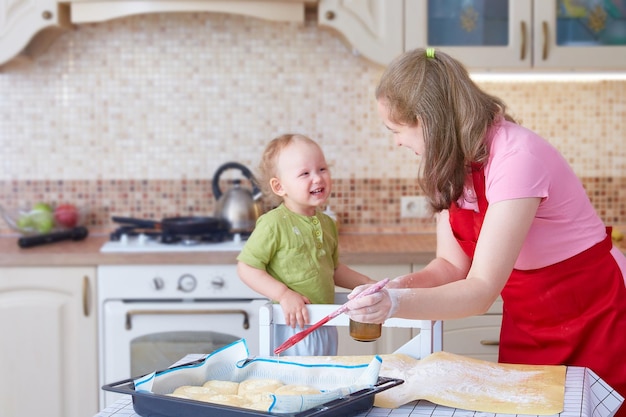 Mãe e filha cozinham tortas na cozinha em casa