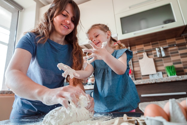 Mãe e filha cozinhando na cozinha