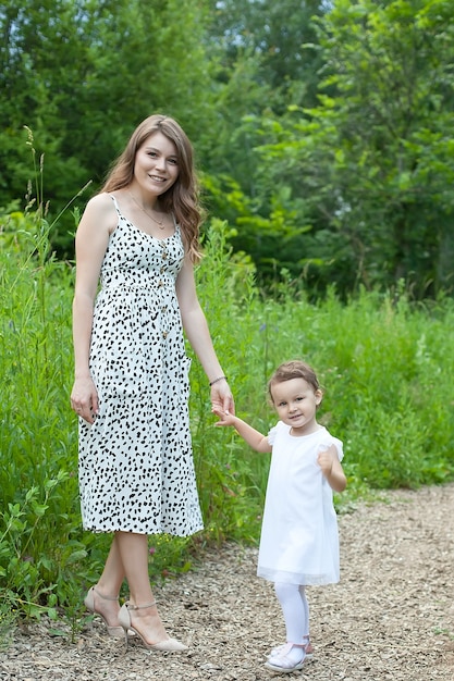 Mãe e filha criança caminhando no prado