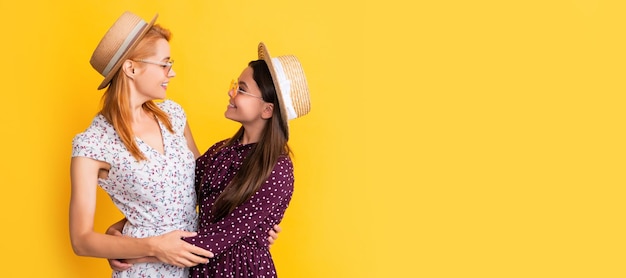 Mãe e filha criança cópia espaço isolado fundo sorrindo mãe e filha com chapéu de palha em fundo amarelo