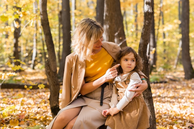 Mãe e filha curtindo um belo dia de outono em um conceito familiar e infantil na temporada de parque.