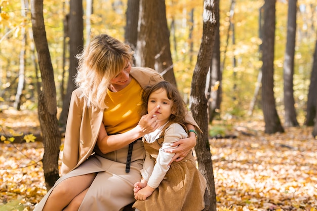 Mãe e filha curtindo um belo dia de outono em um conceito familiar e infantil na temporada de parque.