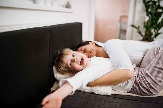 Mãe e filha deitada na cama. Se divertindo.