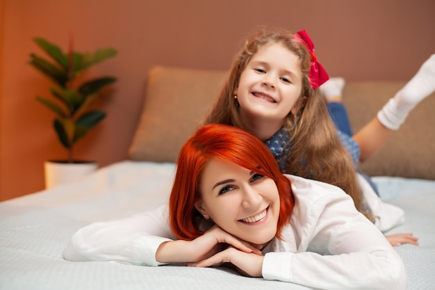 Mãe e filha descansando na cama em casa