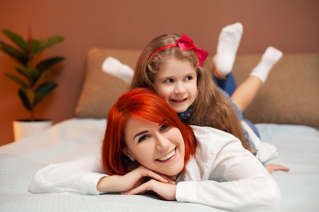 Mãe e filha descansando na cama em casa