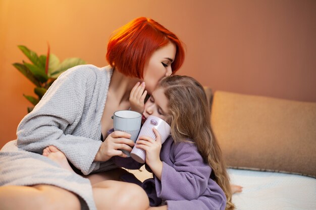 Mãe e filha descansando na cama em casa