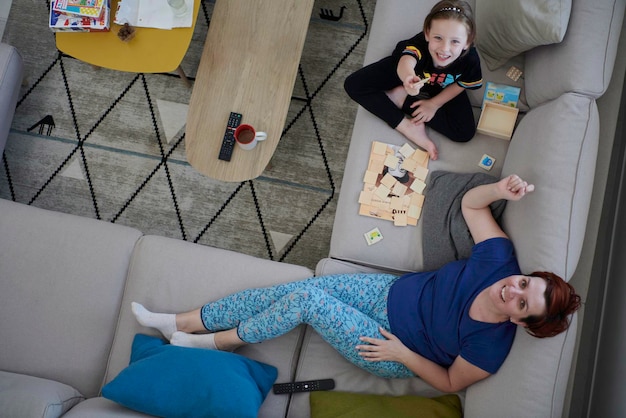 mãe e filha em casa jogando jogo de memória vista superior