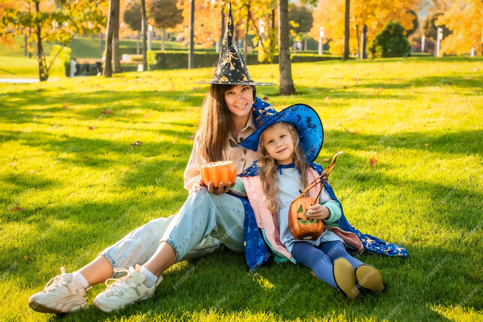 Foto Feliz Dia das Bruxas! Jovem atraente com sua pequena filha